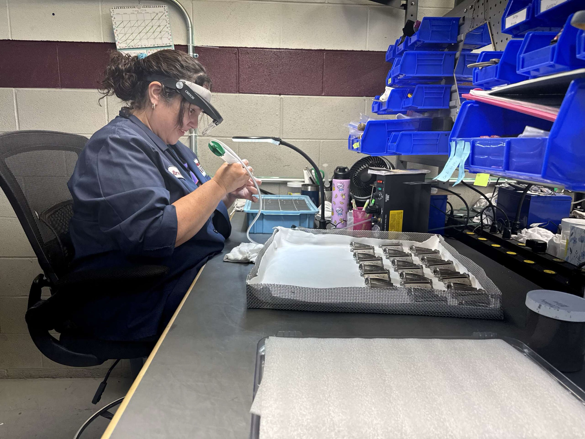 An HTG inspector checking brazed parts at the bench